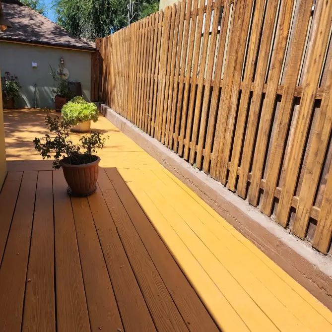 Stained wood deck boards and matching privacy fence after a fresh sealer coat