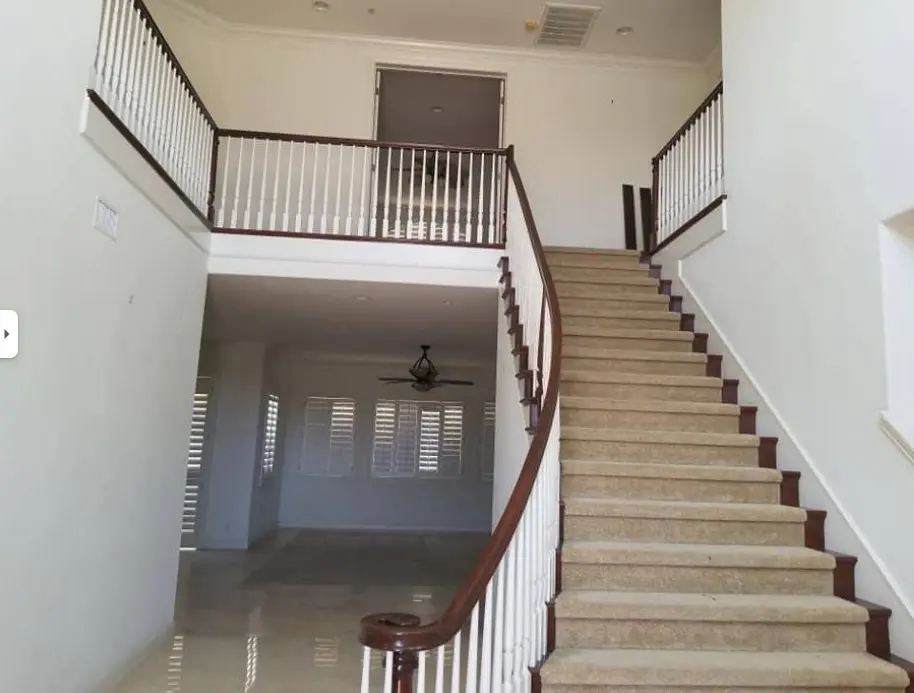 Two-story entry with a curved staircase and freshly painted white walls