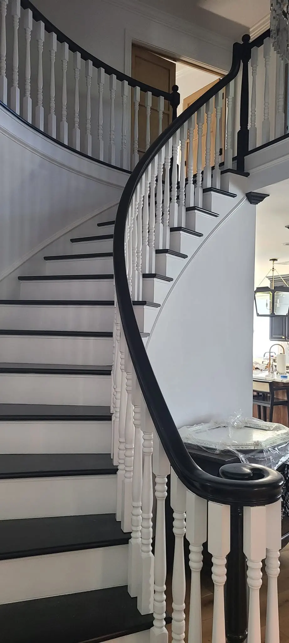 Dark-stained curved handrail contrasted against a white painted stair stringer