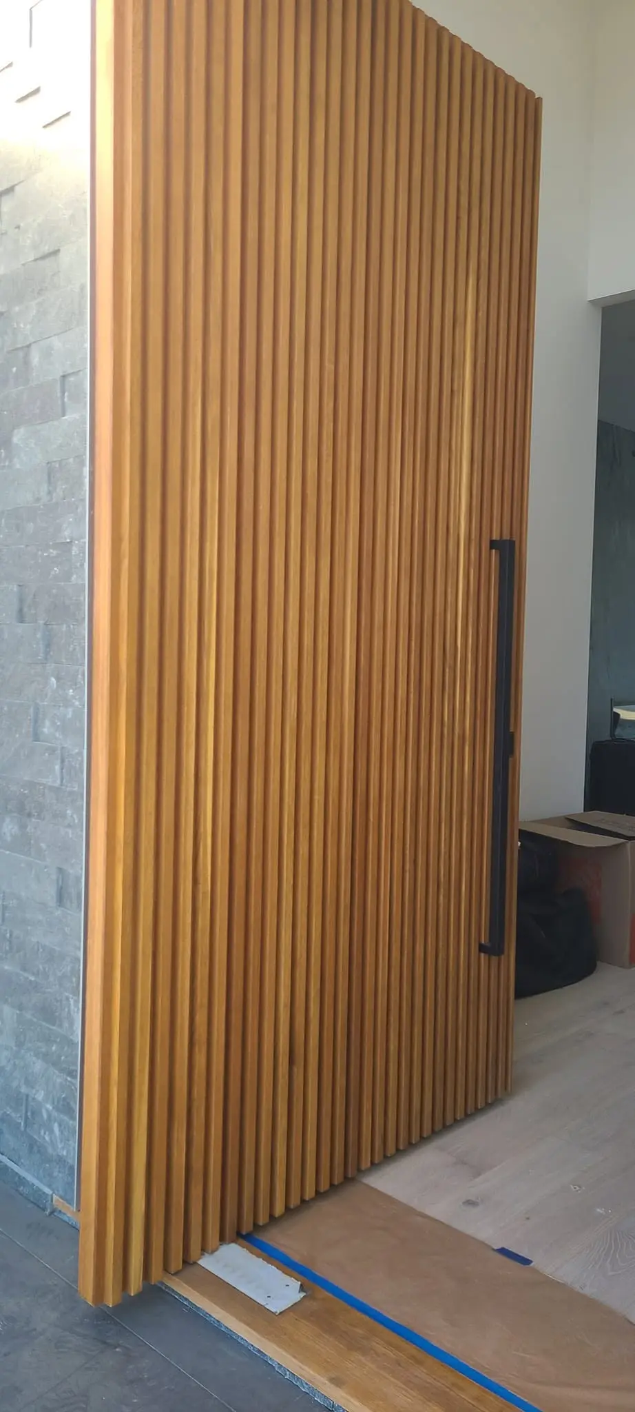Vertical wood slat feature wall finished with clear lacquer in an entryway